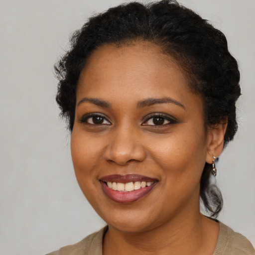 Joyful black young-adult female with short  brown hair and brown eyes