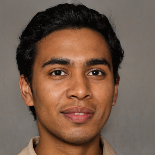 Joyful latino young-adult male with short  brown hair and brown eyes