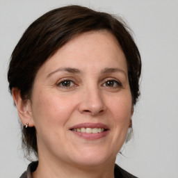 Joyful white adult female with medium  brown hair and grey eyes