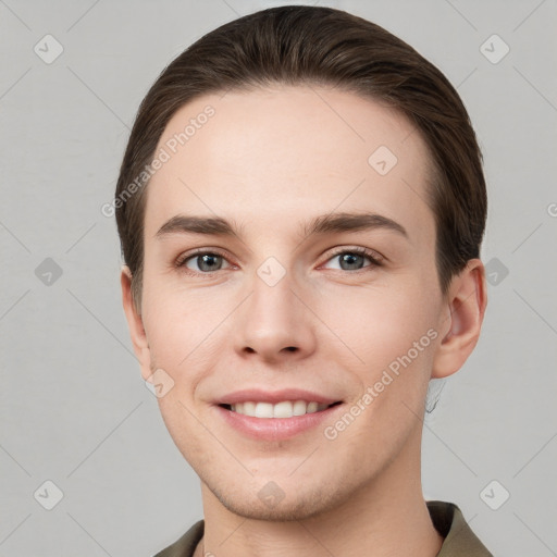 Joyful white young-adult male with short  brown hair and grey eyes