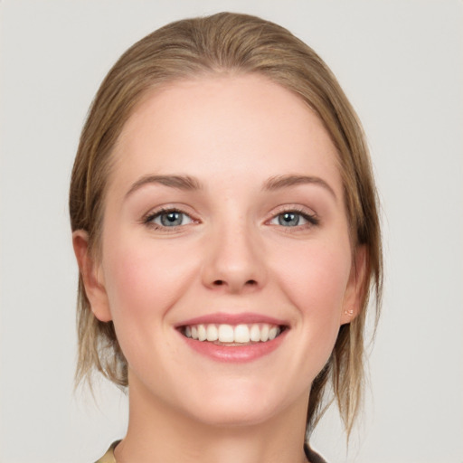 Joyful white young-adult female with medium  brown hair and grey eyes