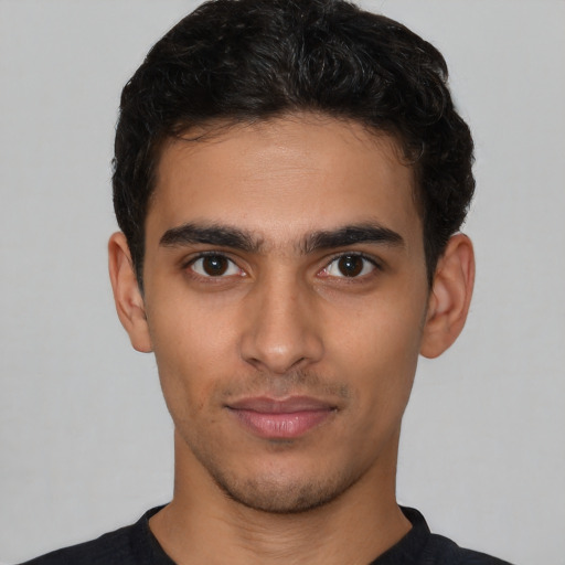 Joyful latino young-adult male with short  brown hair and brown eyes