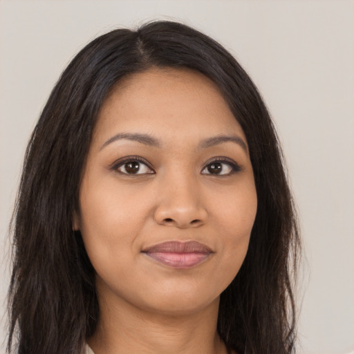 Joyful latino young-adult female with long  brown hair and brown eyes