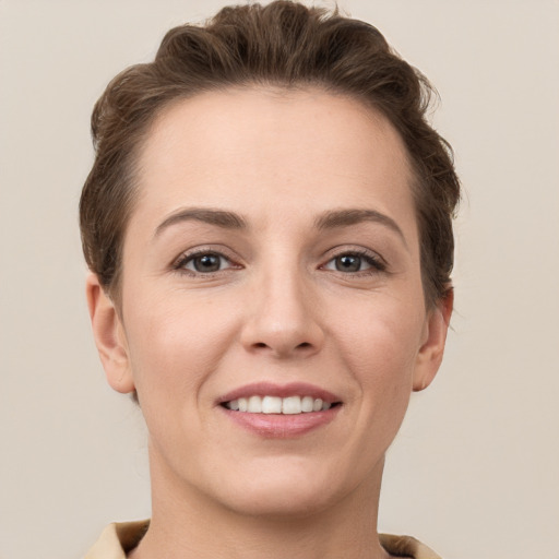 Joyful white young-adult female with short  brown hair and grey eyes