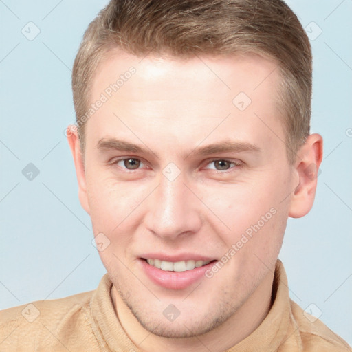 Joyful white young-adult male with short  brown hair and grey eyes