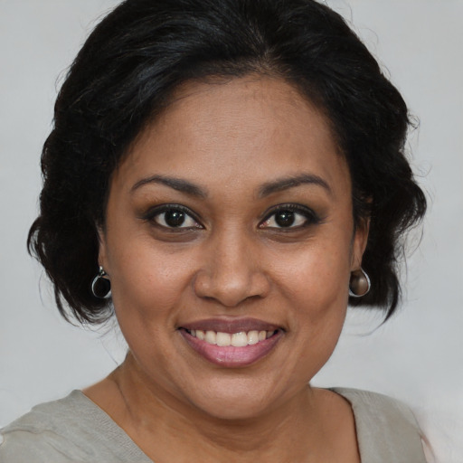 Joyful black young-adult female with medium  brown hair and brown eyes