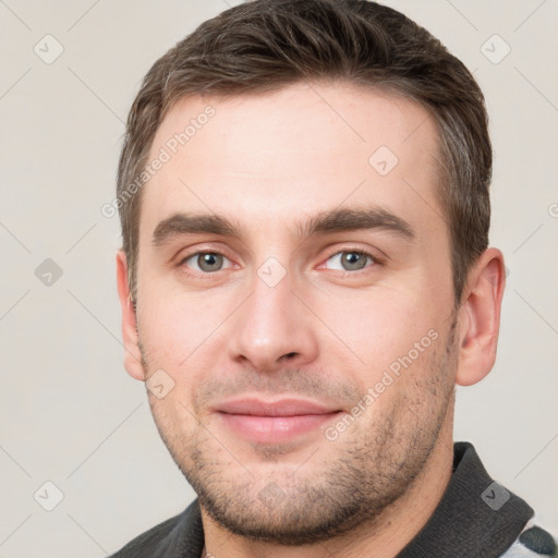 Joyful white young-adult male with short  brown hair and grey eyes