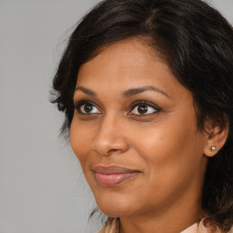 Joyful black adult female with medium  brown hair and brown eyes