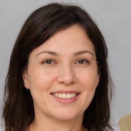 Joyful white adult female with medium  brown hair and brown eyes