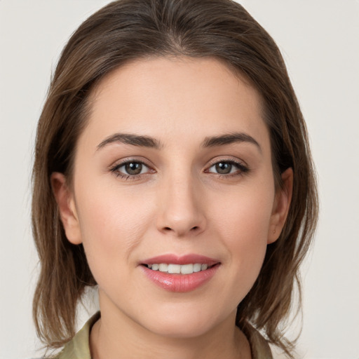 Joyful white young-adult female with medium  brown hair and grey eyes