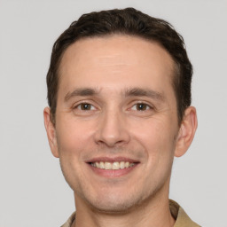 Joyful white young-adult male with short  brown hair and grey eyes