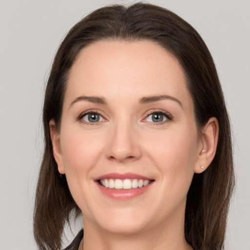 Joyful white young-adult female with long  brown hair and grey eyes