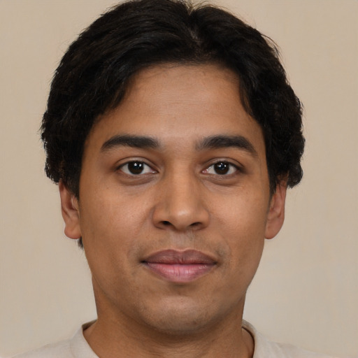 Joyful latino young-adult male with short  black hair and brown eyes