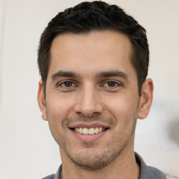 Joyful white young-adult male with short  black hair and brown eyes