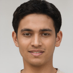 Joyful latino young-adult male with short  brown hair and brown eyes