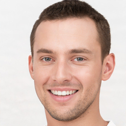 Joyful white young-adult male with short  brown hair and grey eyes