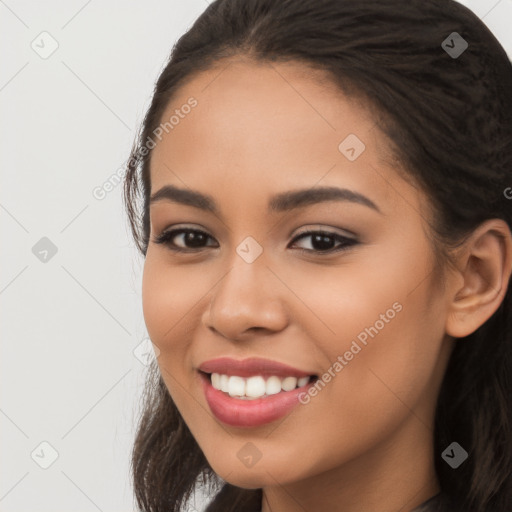 Joyful latino young-adult female with long  brown hair and brown eyes