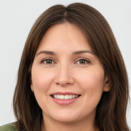 Joyful white young-adult female with long  brown hair and brown eyes