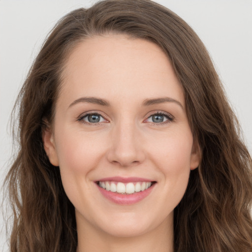 Joyful white young-adult female with long  brown hair and grey eyes