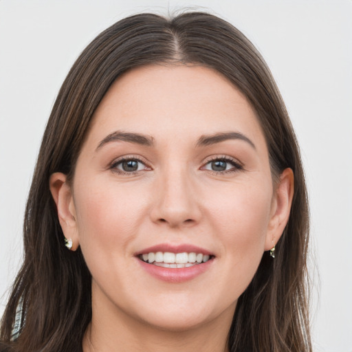 Joyful white young-adult female with long  brown hair and grey eyes