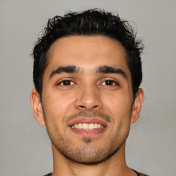 Joyful latino young-adult male with short  black hair and brown eyes