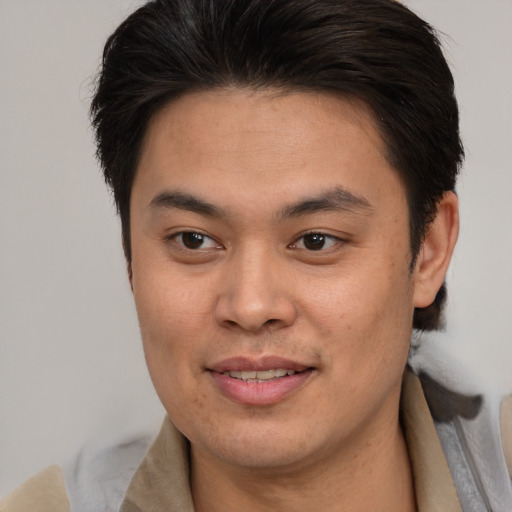 Joyful asian young-adult male with medium  brown hair and brown eyes
