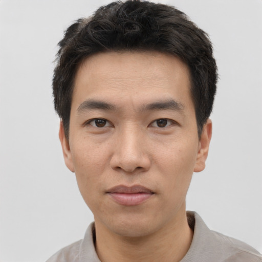 Joyful asian young-adult male with short  black hair and brown eyes