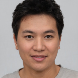 Joyful asian young-adult male with short  brown hair and brown eyes