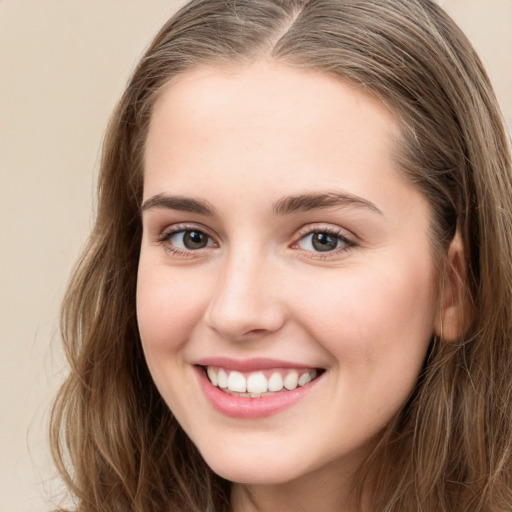 Joyful white young-adult female with long  brown hair and green eyes