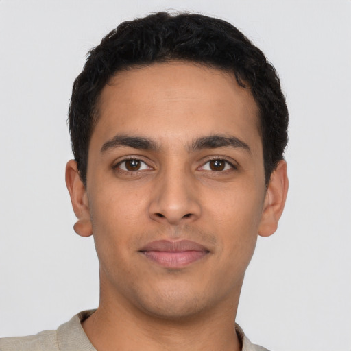 Joyful latino young-adult male with short  brown hair and brown eyes