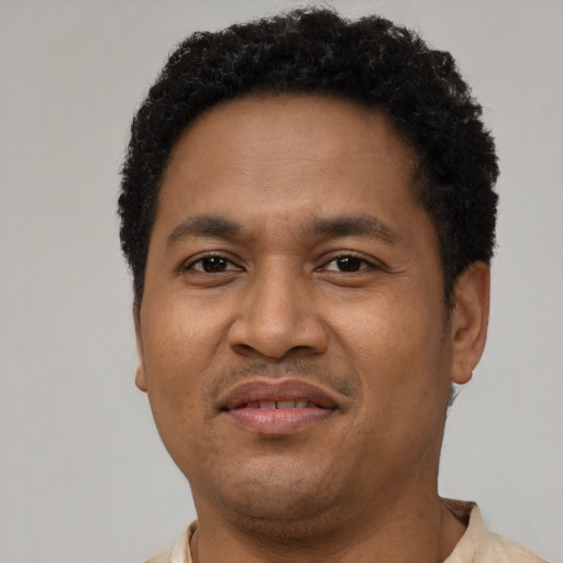 Joyful latino adult male with short  black hair and brown eyes