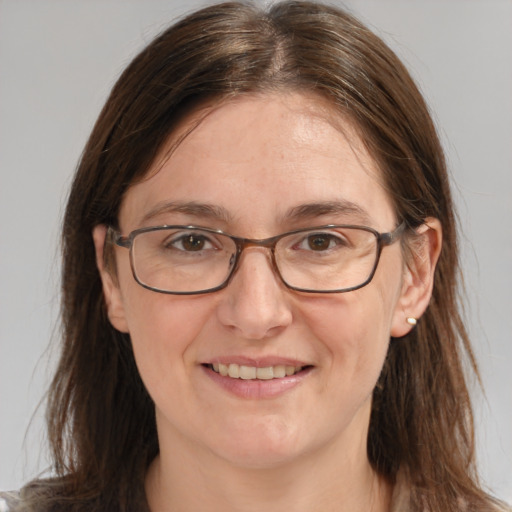 Joyful white adult female with long  brown hair and grey eyes