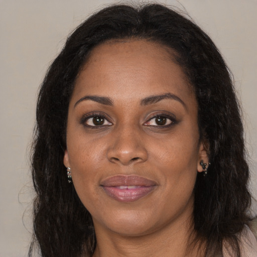 Joyful black adult female with long  brown hair and brown eyes