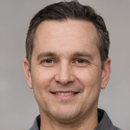 Joyful white adult male with short  brown hair and grey eyes