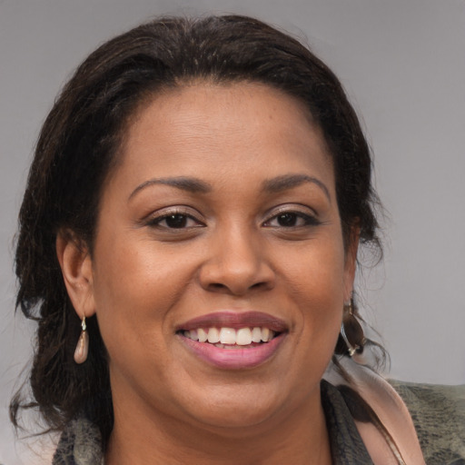 Joyful black adult female with medium  brown hair and brown eyes