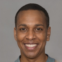 Joyful black adult male with short  black hair and brown eyes