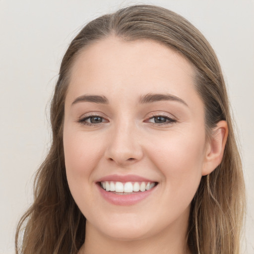 Joyful white young-adult female with long  brown hair and grey eyes