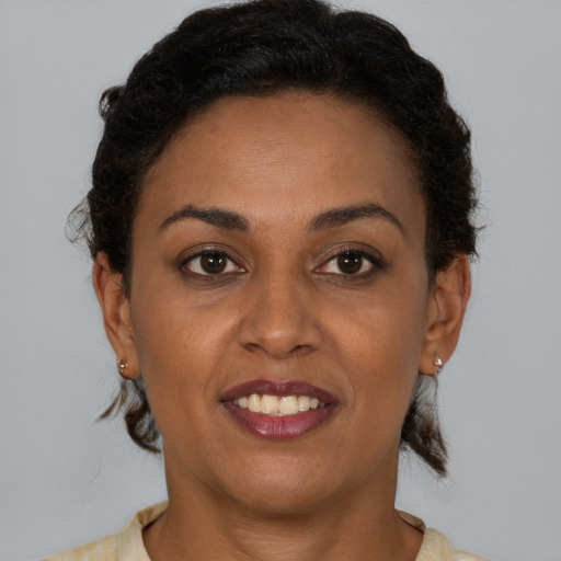 Joyful black young-adult female with short  brown hair and brown eyes