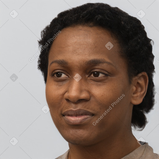 Joyful black young-adult female with short  black hair and brown eyes