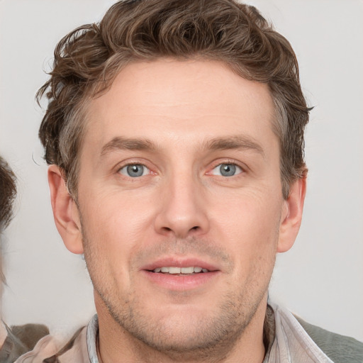 Joyful white adult male with short  brown hair and grey eyes