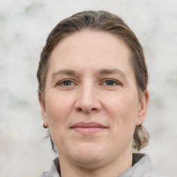 Joyful white adult female with medium  brown hair and grey eyes