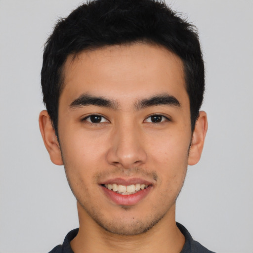 Joyful latino young-adult male with short  brown hair and brown eyes