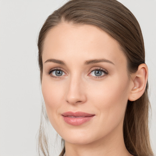 Joyful white young-adult female with long  brown hair and blue eyes