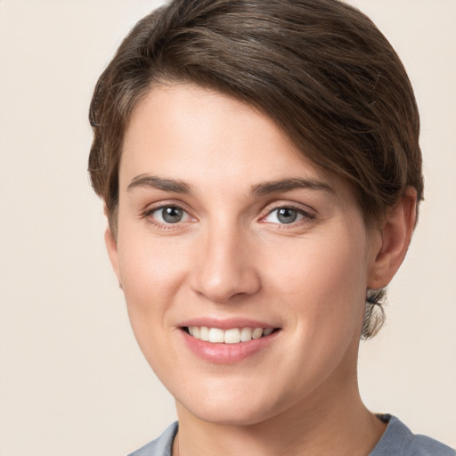 Joyful white young-adult female with short  brown hair and grey eyes