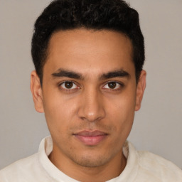 Joyful latino young-adult male with short  brown hair and brown eyes
