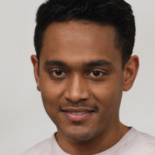 Joyful black young-adult male with short  black hair and brown eyes