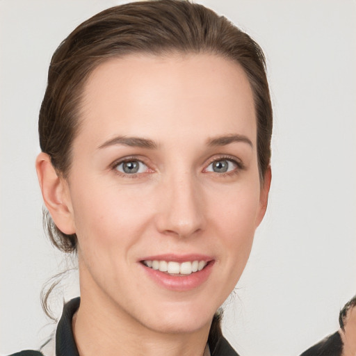 Joyful white young-adult female with medium  brown hair and grey eyes