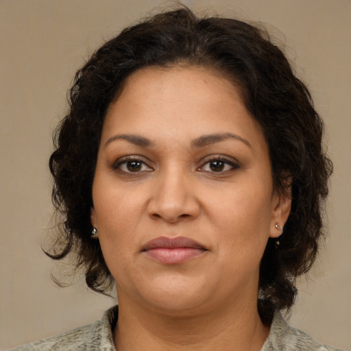 Joyful latino adult female with medium  brown hair and brown eyes