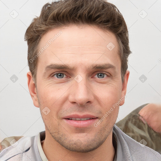 Joyful white young-adult male with short  brown hair and grey eyes