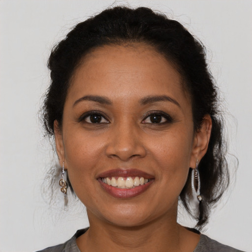 Joyful latino young-adult female with medium  brown hair and brown eyes